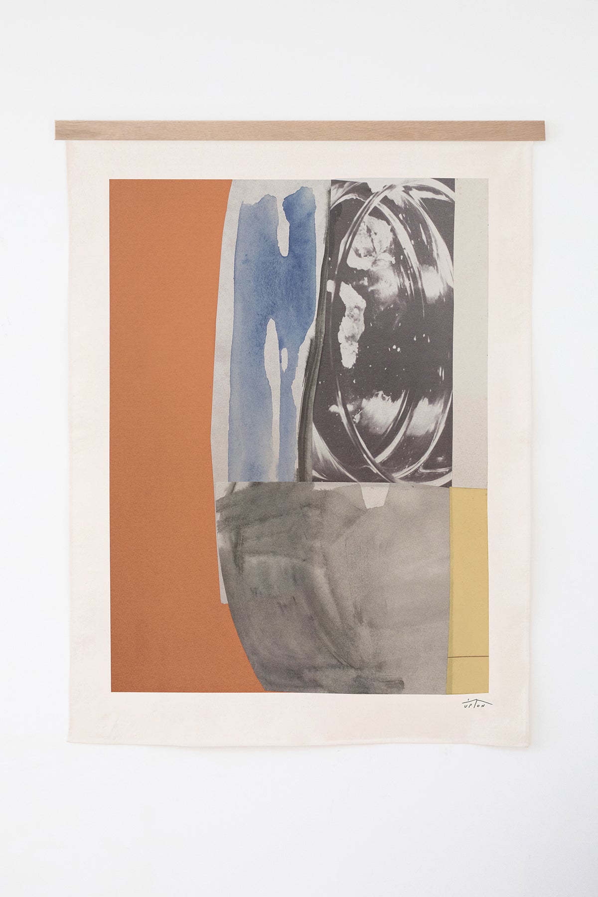 The Dahr is an original art print on 100% cotton canvas from Michael Upton. Featuring an abstract collage design in muted primary colors, the Dahr is a large format modern wall hanging. Shown here with a wood hanging bar on a white background.