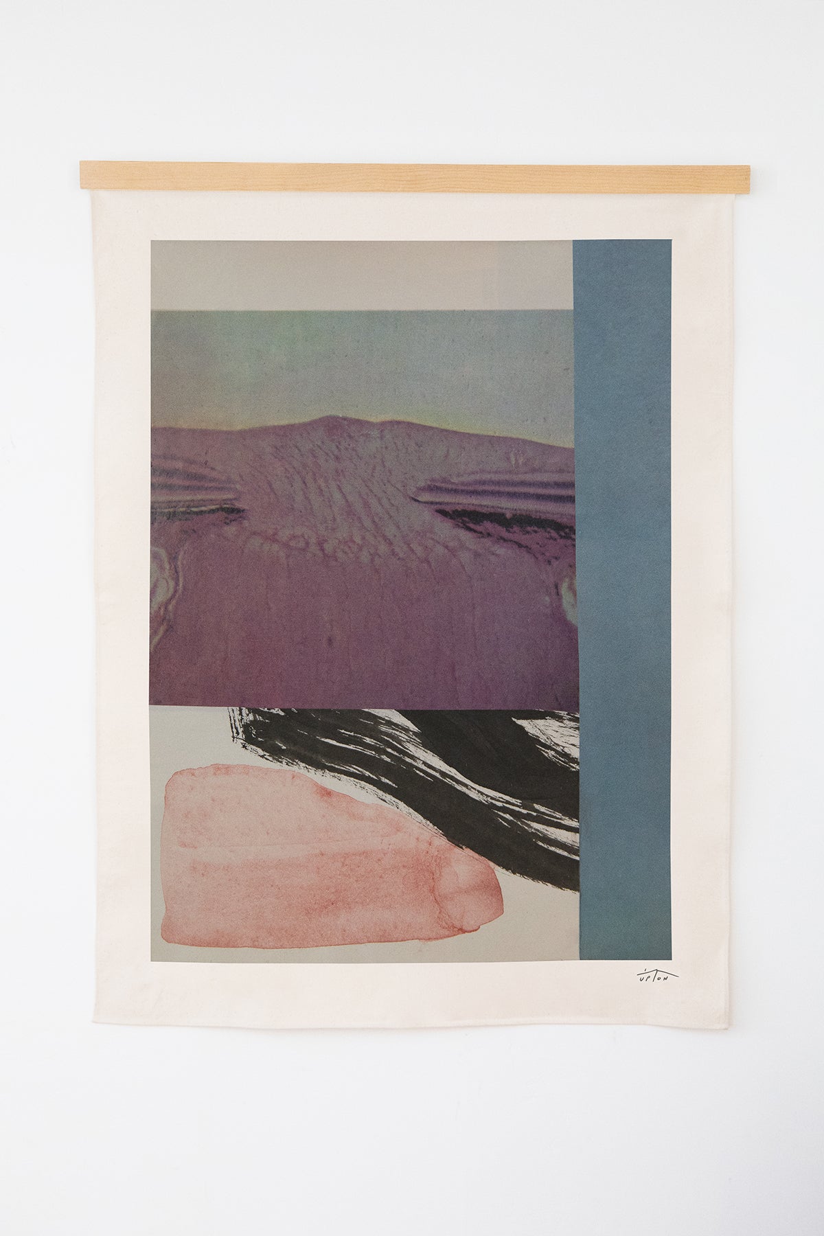 The Lomond is an original art print on 100% cotton canvas from Michael Upton. Featuring abstract collage design in rich blue and purple hues, the Lomond is a large format modern wall hanging. Shown here with a wood hanging bar on a white background.