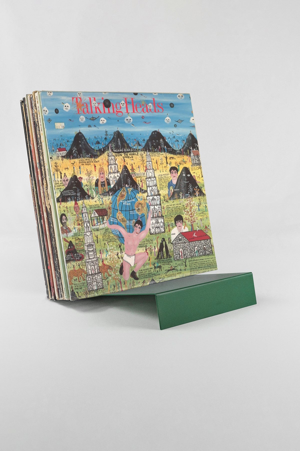 Upton LP Stand in pine. Modern minimalist green metal countertop record stand holding a record on a white background.