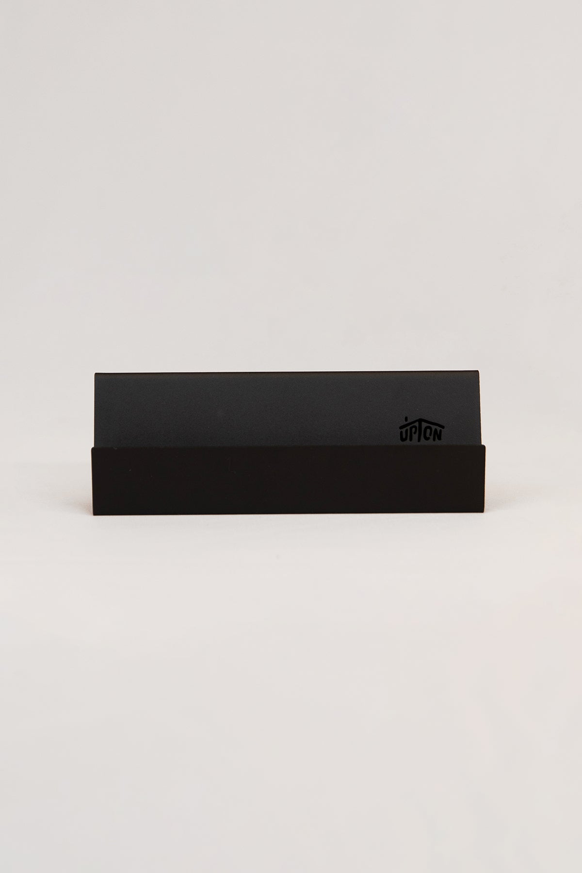 Upton Now Playing Stand in black. Modern and minimalist steel display stand made to hold the record sleeve for the album currently playing on the turntable. Shown on a white background.