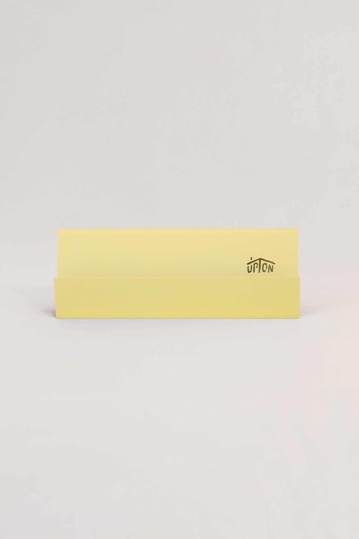 Upton Now Playing Stand in pale yellow. Modern and minimalist steel display stand made to hold the record sleeve for the album currently playing on the turntable. Shown on a white background.