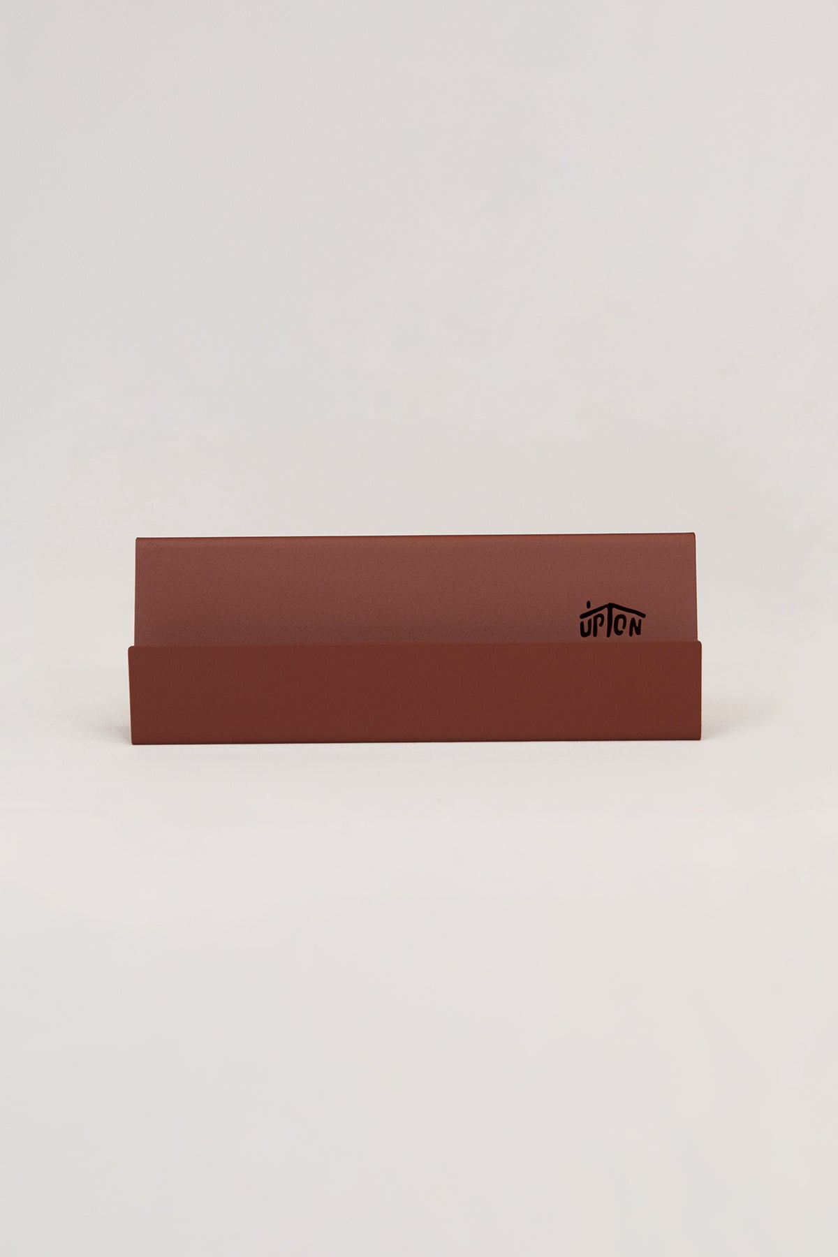 Upton Now Playing Stand in rose (red/pink). Modern and minimalist steel display stand made to hold the record sleeve for the album currently playing on the turntable. Shown on a white background.