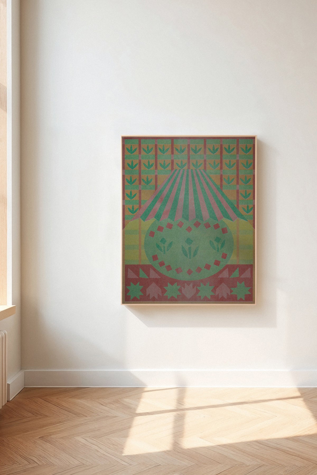 Lamplight by Sunroom Studios x Upton, a custom framed art print on 100% cotton canvas. Large cut paper collage featuring a stylized lamp in muted greens, pinks, reds, starbursts, and floral patterns. Originally created as a risograph print. Shown in a gallery setting with wood floors and natural light.