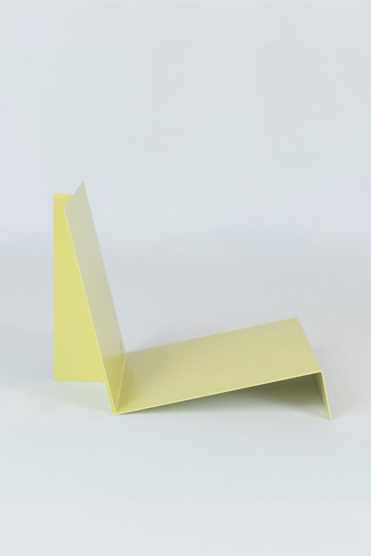 Upton LP Stand in pale yellow. Modern and minimalist tabletop steel vinyl record holder made for storage, organization, and display of 50 albums on a white background.