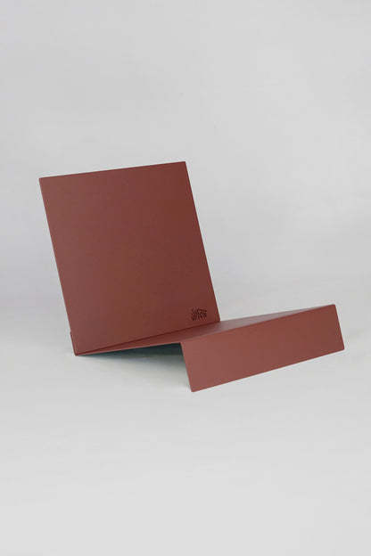 Upton LP Stand in rose (pink/red). Modern and minimalist tabletop steel vinyl record holder made for storage, organization, and display of 50 albums on a white background.