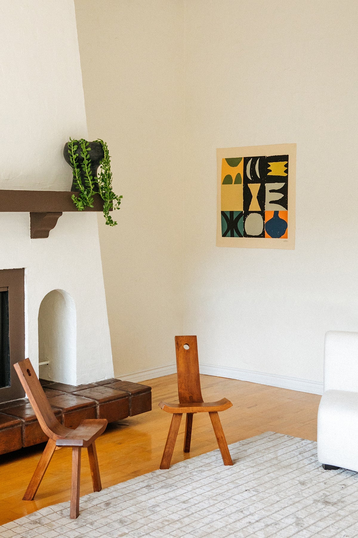 The Briton is an original art print on 100% cotton canvas from Michael Upton. Featuring a geometric abstract mosaic design with bold colorful shapes, the Briton is a large format modern wall hanging. Shown here in a modern living room with handmade wooden chairs, fireplace and houseplant.