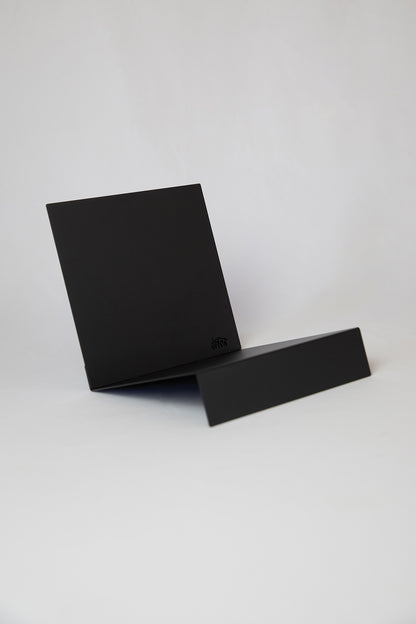 Upton LP Record Stand in black. Modern and minimalist tabletop steel vinyl record holder made for the storage, organization, and display 50 albums. Shown on a white background.
