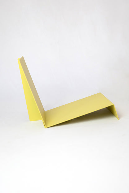 Upton LP Record Stand in pale yellow. Modern and minimalist tabletop steel vinyl record holder made for the storage, organization, and display 50 albums. Shown from the side on a white background.