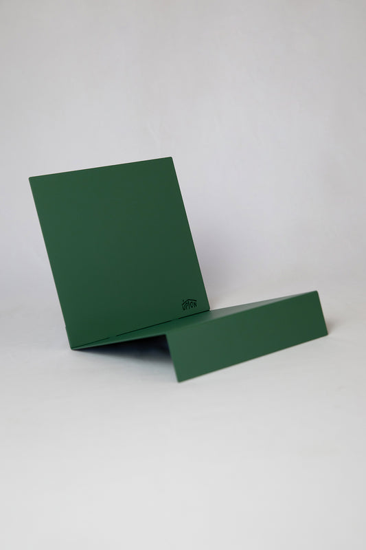 Upton LP Record Stand in pine green. Modern and minimalist tabletop steel vinyl record holder made for the storage, organization, and display 50 albums. Shown on a white background.