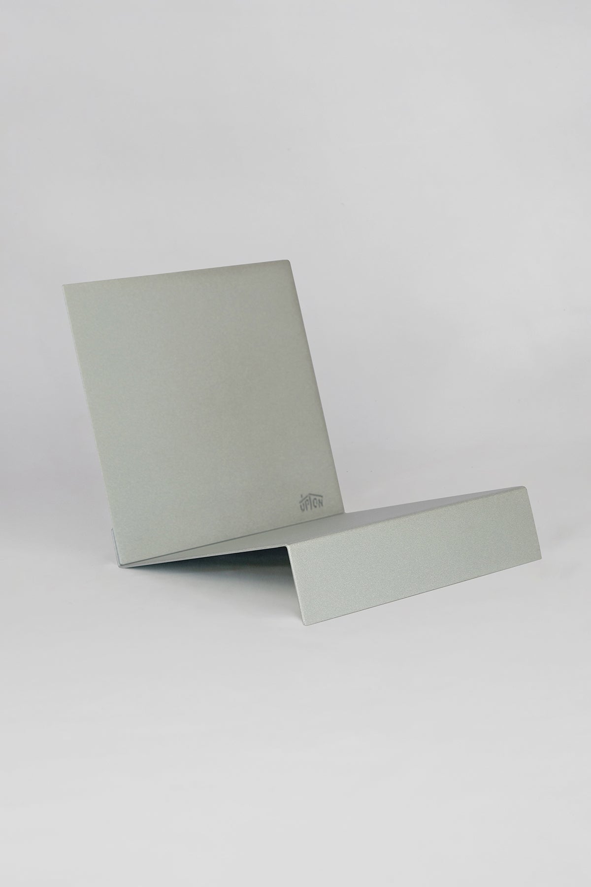 Upton LP Stand in silver. Sculptural steel storage and display stand made to hold records on a white background