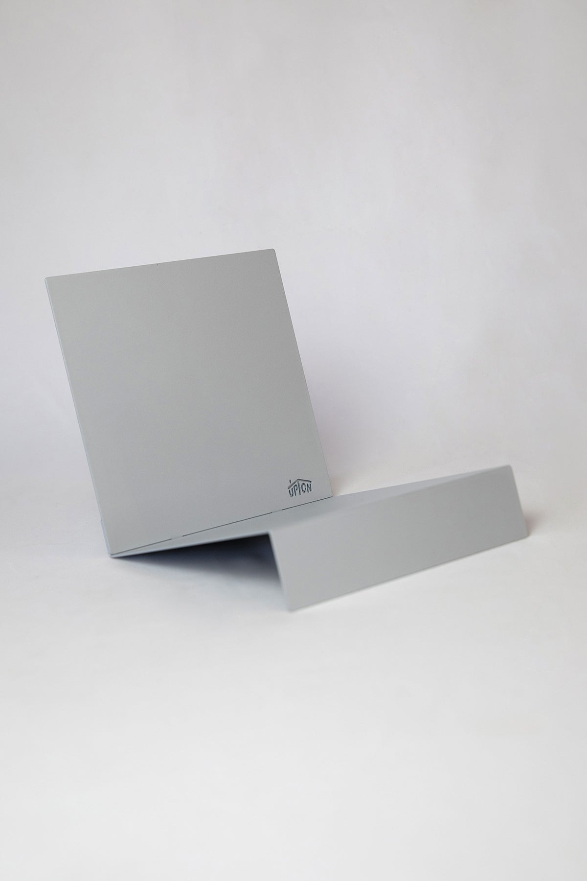 Upton LP Record Stand in matte silver. Modern and minimalist tabletop steel vinyl record holder made for the storage, organization, and display 50 albums. Shown on a white background.