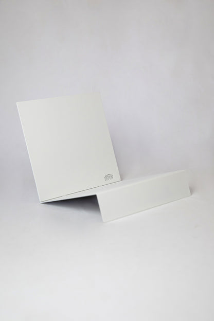 Upton LP Record Stand in white. Modern and minimalist tabletop steel vinyl record holder made for the storage, organization, and display 50 albums. Shown on a white background.