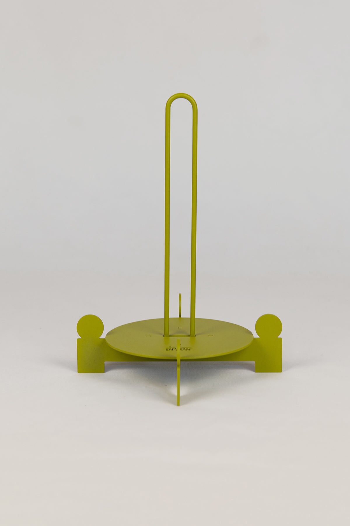 Upton Bal Paper Towel Holder. Green metal paper towel holder with circular base and vertical rod on a white background.
