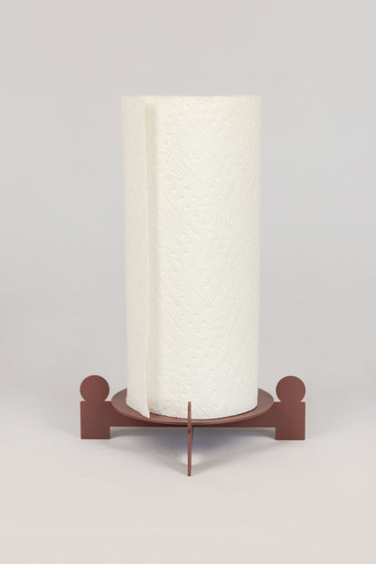 Upton Bal Paper Towel Holder in rose. Sculptural metal paper towel holder with paper towel roll, in front of a white background.