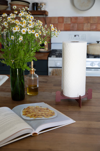 Kitchen counter with Upton Bal Paper Towel Holder, with open cookbook, paper towels, and flowers