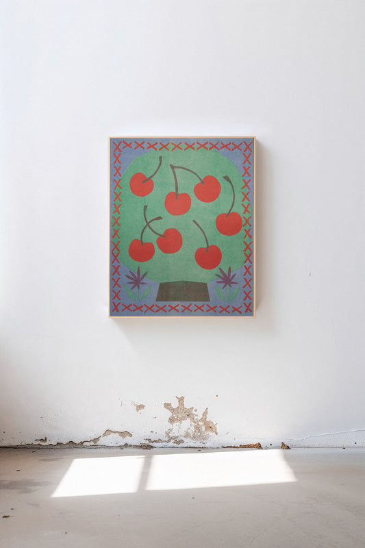 Cherry Tree by Sunroom Studios x Upton, a custom framed art print on 100% cotton canvas. Large cut paper collage of a stylized cherry tree in cheerful reds, greens, and blues, shown in a gallery setting with concrete floors and natural light.