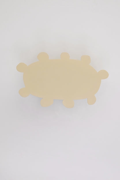 Upton Soli Wall Hook in butter. A sculptural decorative steel wall hook with a butter yellow color scheme with a unique abstract shape, designed to hang bags, coats, towels, hats, and more. Shown here on a white background.